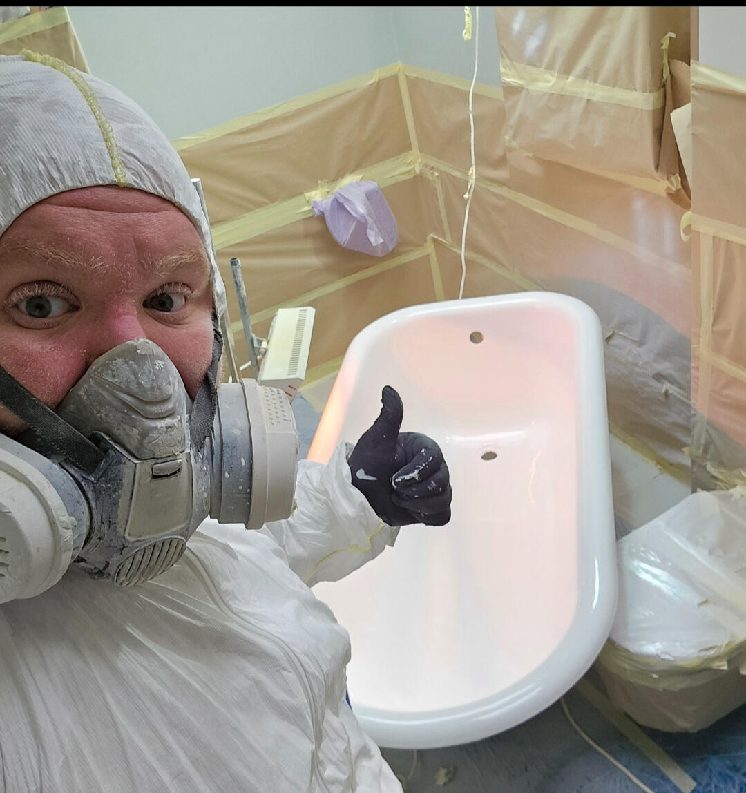 photo of glossy baths owner photo of glossy baths re-enamelling owner Seamus with a thumbs up, in ppe, in a room full of masking up and a completed bath in Weston-super-Mare